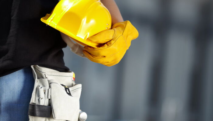 Worker holds safety helmet